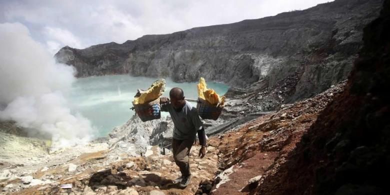 Marzuki, seorang petambang berjalan membawa bakul penuh bongkahan belerang, saat naik dari kawah Gunung Ijen di Banyuwangi, Jawa Timur, Sabtu (16/4/2016). Demi mendapat penghasilan yang terbilang minim, petambang harus menapaki gunung dengan memanggul puluhan kilogram bongkahan belerang di tengah asap beracun. 