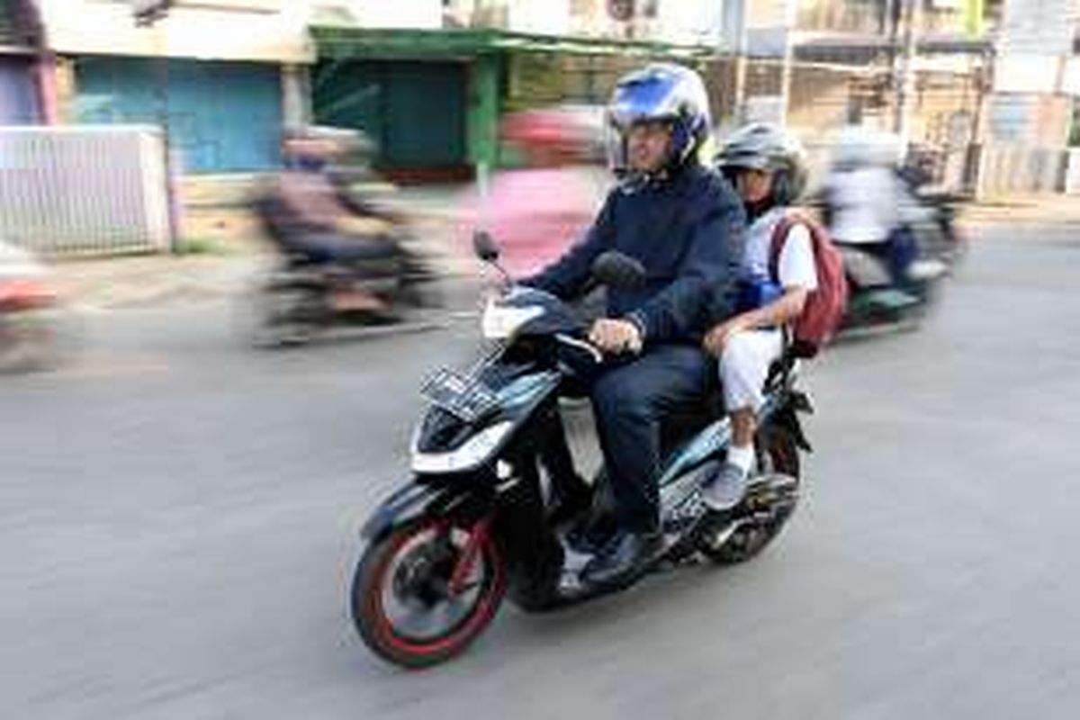 Mantan Menteri Pendidikan dan Kebudayaan Anies Baswedan mengantar putranya, Kaisar Hakam Baswedan, dengan sepeda motor pada hari pertama masuk sekolah di Cinere, Depok, Jawa Barat, Senin (1/8/2016). Saat menjabat menteri, Anies mengampanyekan Gerakan Antar Anak Ke Sekolah pada hari pertama masuk sekolah.