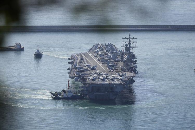 Kapal induk AS USS Ronald Reagan dikawal ke Pangkalan Angkatan Laut Busan di Busan, Korea Selatan, Jumat (23/9/2022). USS Ronald Reagan tiba untuk berpartisipasi dalam latihan militer bersama yang akan datang dengan Korea Selatan di Laut Timur, pertama kalinya sejak 2017. 
