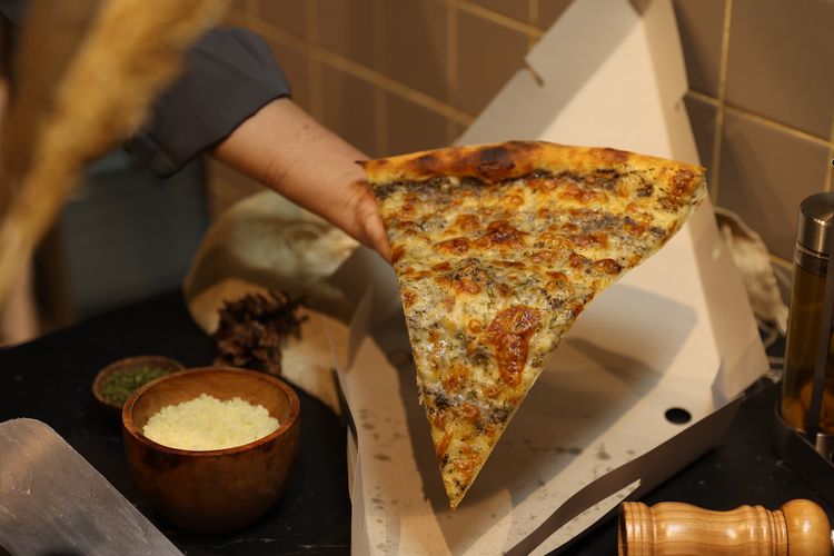 Irisan piza besar ala Sliced Pizzeria Jakarta.