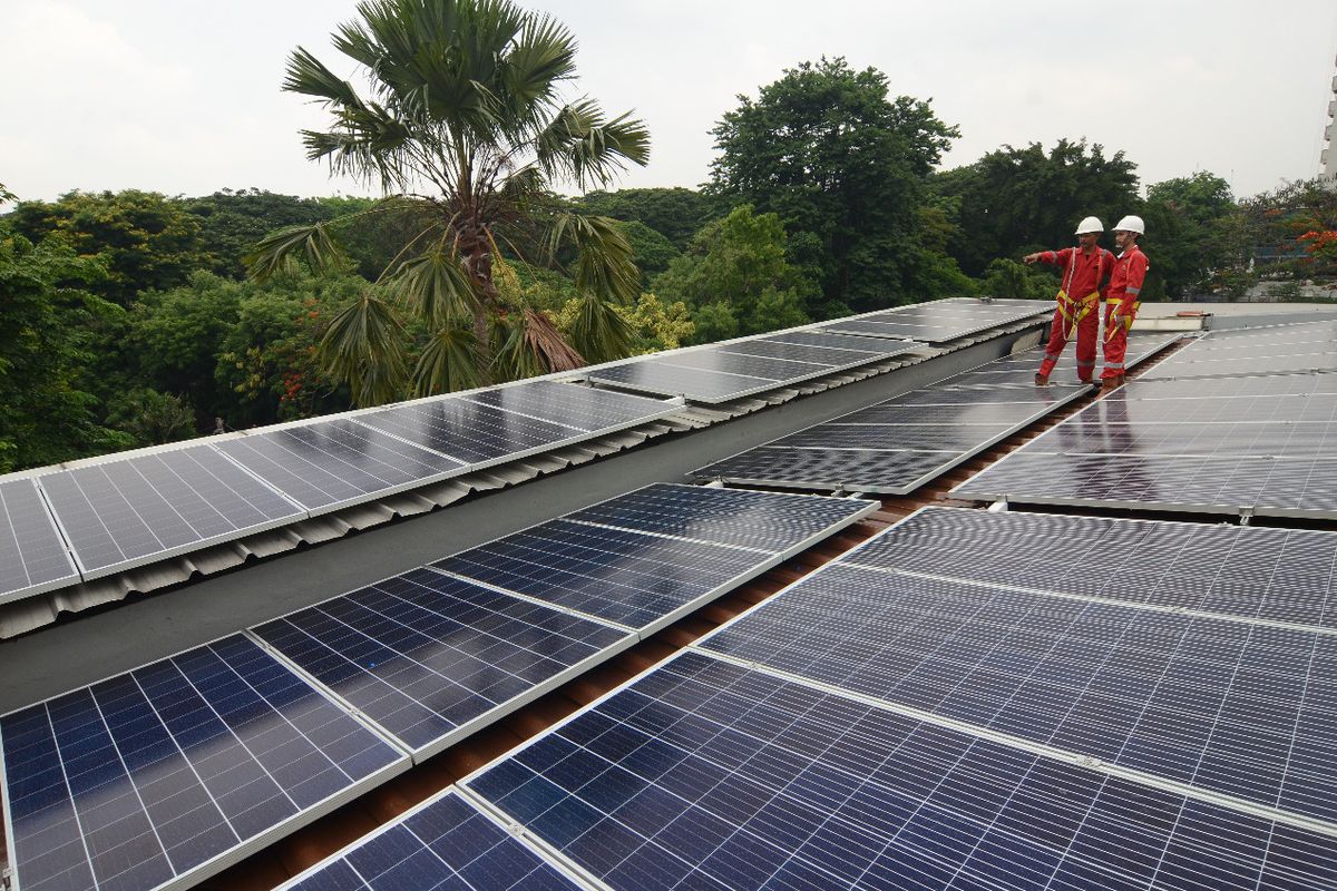 Dua orang pekerja tengah memasang solar panel. Teknologi ini merupakan energi baru terbarukan (EBT) yang diproduksi PT Len Industri. 