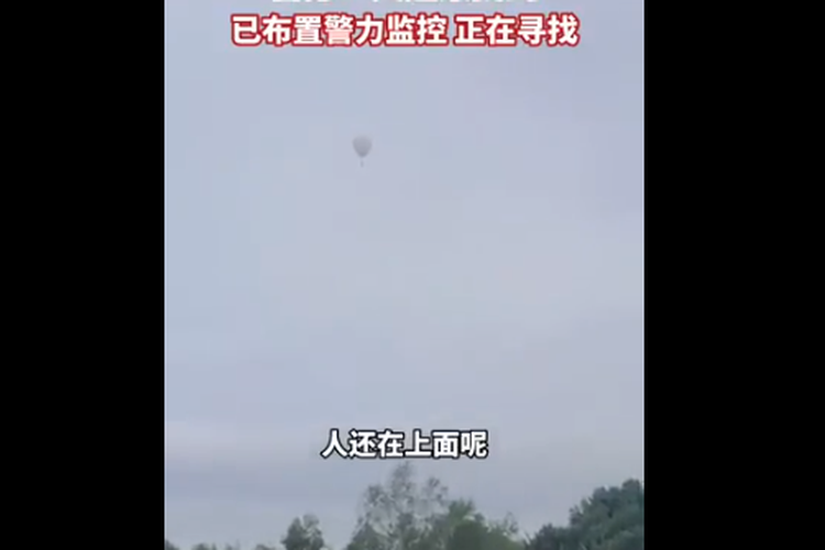 Tangkap layar video yang beredar di platform media sosial China Weibo menunjukkan balon berwarna putih melayang di langit di atas hutan pinus yang lebat.
