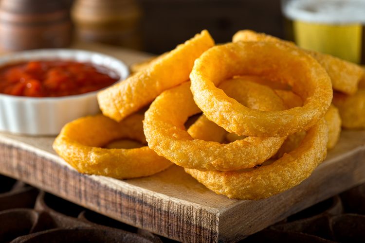 Ilustrasi onion ring pakai saus tomat. 