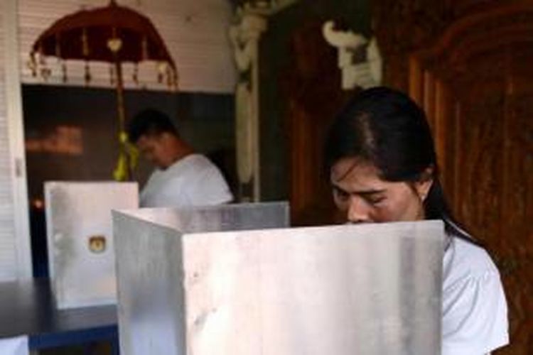 Warga bali memberikan suara mereka di tempat pemungutan suara di Kuta, Bali, 9 Desember 2015. 100 juta pemilih hari ini memberikan suara untuk pemilihan kepala daerah yang dilakukan serentak di 32 provinsi untuk pertama kalinya.