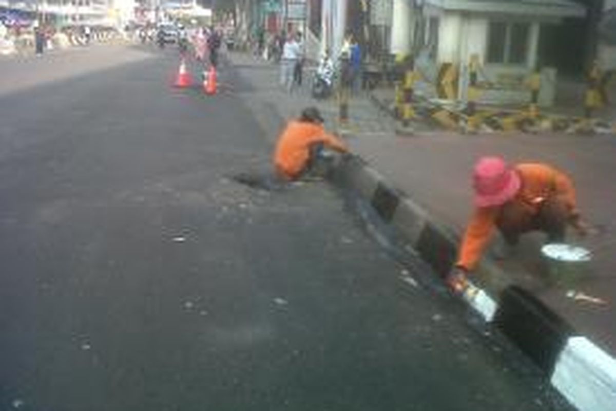 Petugas dari Suku Dinas Kebersihan Jakarta Pusat mengecat trotoar di Jalan Kebon Jati, Pasar Tanah Abang, Jakarta Pusat, Senin (12/8/2013). Arus lalu lintas di jalan tersebut lebih lancar setelah pedagang kaki lima di sepanjang jalan itu ditertibkan.