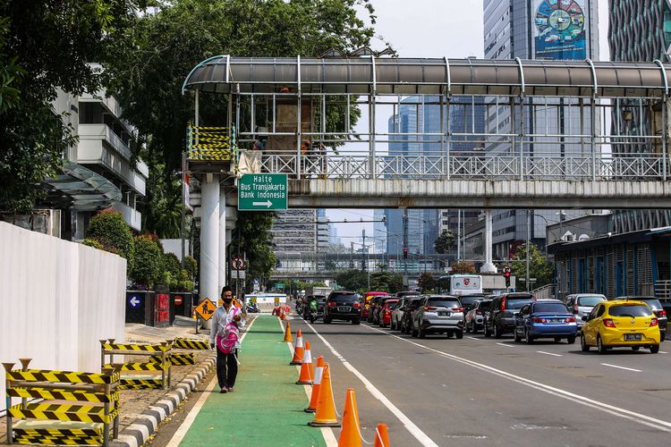Pekerja menggunakan masker saat berjalan di Jalan M.H Thamrin, Jakarta Pusat, Rabu (16/9/2020). PSBB kembali diterapkan tanggal 14 September 2020, berbagai aktivitas kembali dibatasi yakni aktivitas perkantoran, usaha, transportasi, hingga fasilitas umum.