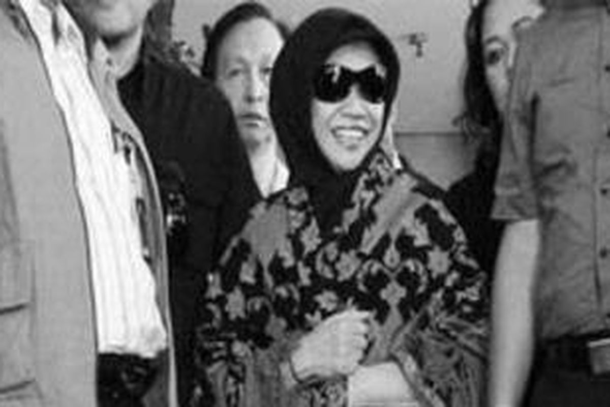 Tersangka Nunun Nurbaeti tersenyum saat keluar dari Gedung KPK, Jakarta, seusai diperiksa dalam kasus cek perjalanan pada pemilihan Deputi Gubernur Senior Bank Indonesia 2004, Selasa (27/12).