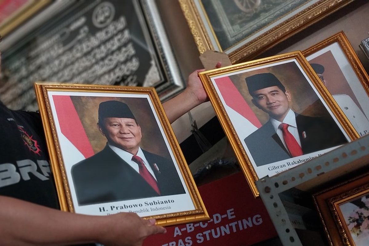 Rudi (40), penjual sekaligua perajin bingkai RD Frame Tasikmalaya, Jawa Barat, menunjukkan bingkai produksinya dengan foto Prabowo-Gibran yang tak resmi sebagai contoh penjualan di tokonya, Senin (21/10/2024).