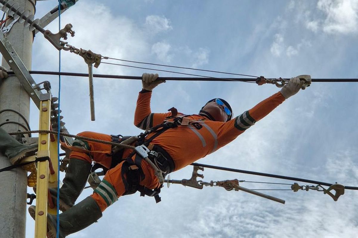 Personel PLN melakukan penarikan kabel saluran udara tegangan menengah (SUTM) di Panton Labu, Aceh Utara.

