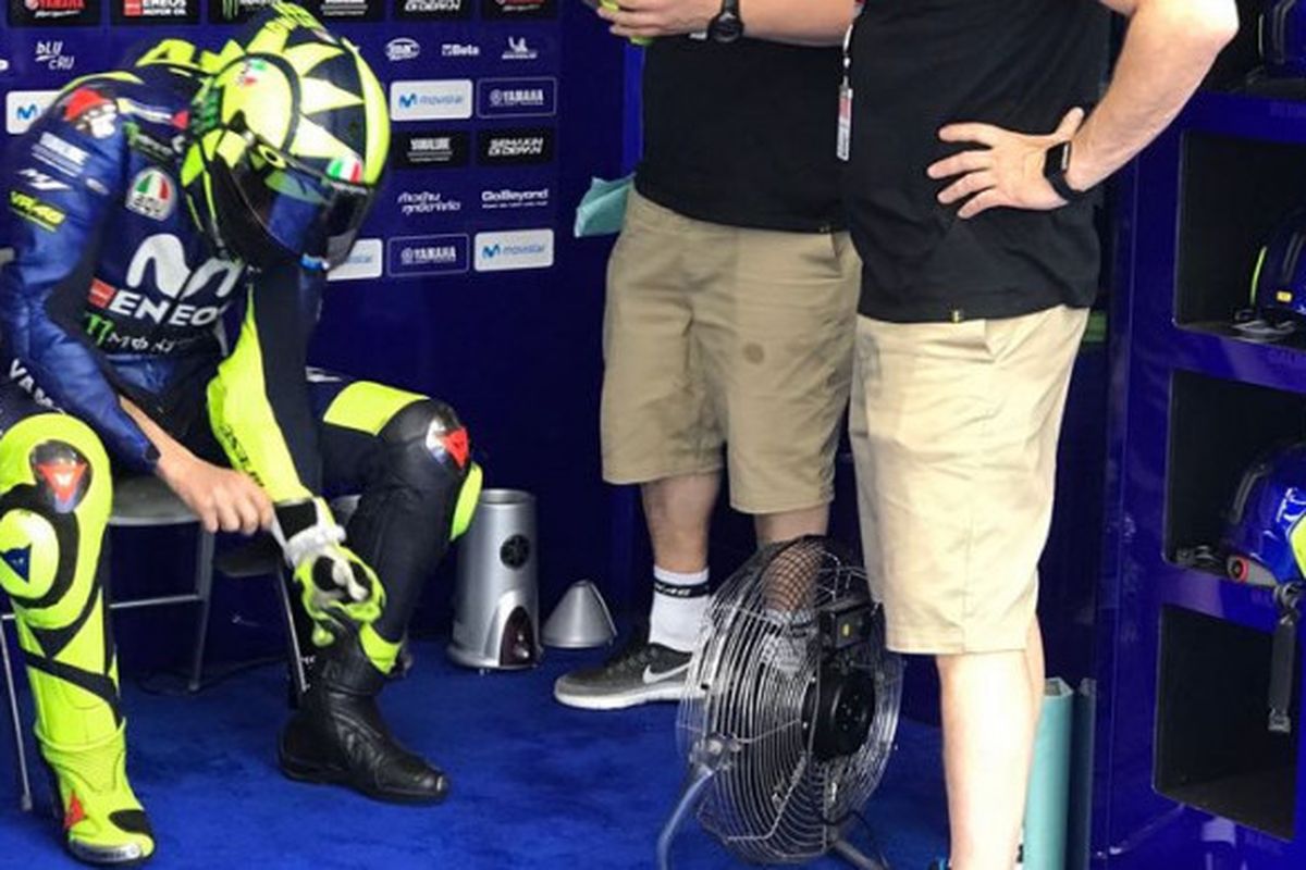 Valentino Rossi (kiri) saat berada di paddock tim Movistar Yamaha ketika MotoGP Argentina sempat ditunda sementara, Minggu (8/4/2018).
