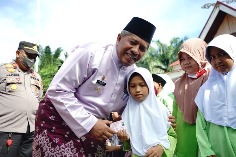 Bupati Siak Alfedri berfoto bersama anak-anak penerimaan bantuan dari Pemerintah Kabupaten (Pemkab) Siak.
