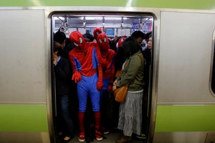 Peserta Halloween, mengenakan kostum Spiderman, naik kereta setelah malam Halloween di distrik Shibuya Tokyo, 1 November 2014.