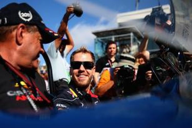 Pebalap Red Bull Racing asal Jerman, Sebastian Vettel mengendarai mobil AC Cobra, pada parade sebelum GP Amerika Serikat dilaksanakan di Austin, Minggu (17/11/2013).