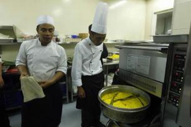 Juru masak membuat nasi kuning untuk nasi tumpeng di dapur Atria Hotel, Serpong, Tangerang, Banten, Jumat (29/5/2015) dini hari. Nasi kuning ini nanti akan dibuat menjadi nasi tumpeng setinggi 1 meter yang dimasak khusus untuk merayakan HUT ke-7 Kompas.com.