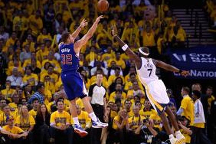 Pebasket Los Angeles Clippers Blake Griffin (kri) melakukan tembakan melewati pemain Golden State Warriors, Jermaine O'Neal, pada laga ketiga babak play-off WIlayah Barat di Oracle Arena, Kamis (24/4/2014). Clippers menang 98-96.
