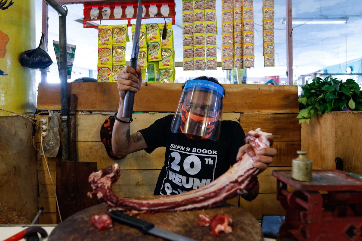 Ayung (38), pedagang di Pasar Sukasari menggunakan face shield saat berdagang, Jumat (5/6/2020). Kementerian Perdagangan menyiapkan pedoman penyelenggara kegiatan perdagangan untuk diterapkan pada saat kenormalan baru dimana pedagang di pasar rakyat diwajibkan menggunakan masker, face shield, dan sarung tangan selama beraktivitas.