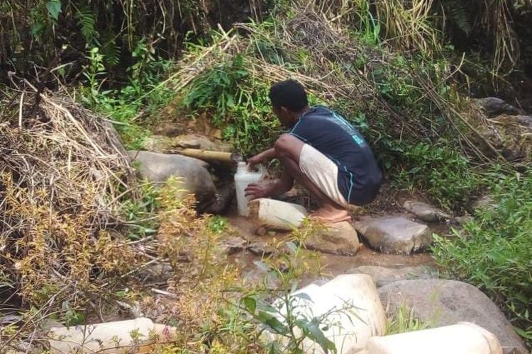 Warga Kampung Tapok, Desa Rengkam, Kecamatan Lamba Leda Timur, Manggarai Timur, NTT, Senin, (25/3/2024) menimba air minum di aliran jaringan bambu.