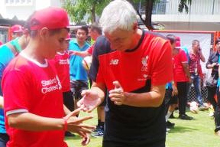 Legenda Liverpool, Ian Rush, memandu salah seorang murid berlatih sepak bola. Sekitar 50 murid Bangkok School For The Blind saat mengikuti sesi klinik kepelatihan yang digelar Liverpool bekerjasama dengan Standard Chartered, Selasa (14/7/2015). 