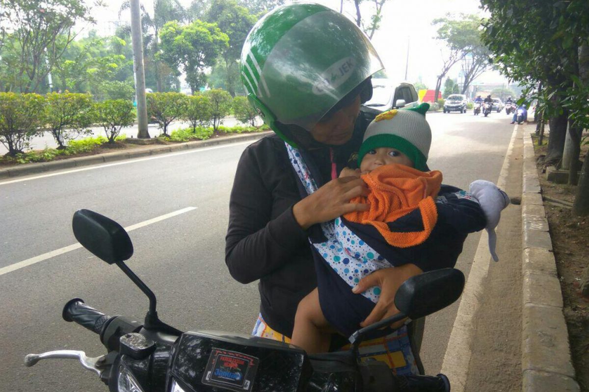 Novita mengendarai sepeda motor sambil menggendong bayi di Jalan Juanda Depok, mengaku akan menuju ke kantor Walikota Jakarta Selatan, Jumat (23/2/2018).