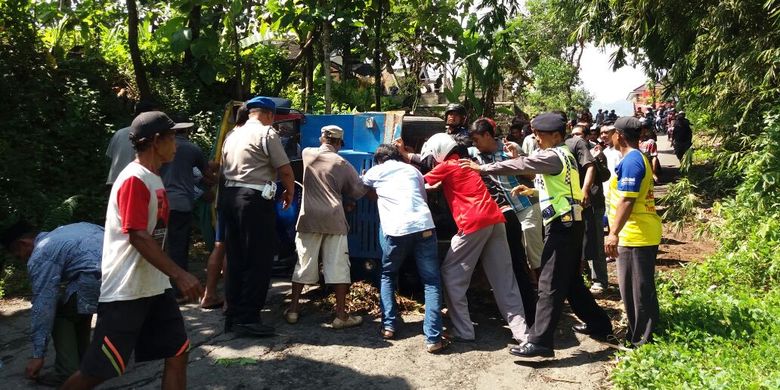 EVAKUASI -Warga membantu mengevakuasi kereta kelinci yang terguling di ruas jalan Dukuh Gembes, Desa Slahung, Kecamatan Slahung, Kabupaten Ponorogo, Rabu ( 1/3/2017).