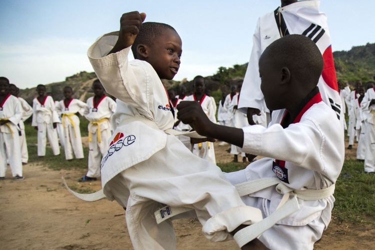 Dua anak dengan tingkatan sabuk putih atau pemula dalam taekwondo sedang berlatih.