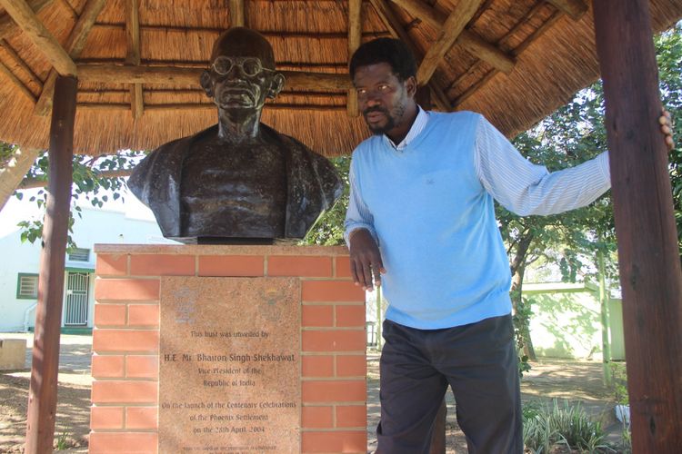 Patung Gandhi di kompleks Phoenix Settlement di Durban, Afrika Selatan. Berdiri di samping patung adalah petugas pengelola sekaligus pendamping tamu, Bongani. Gambar diambil pada Sabtu (10/6/2017)