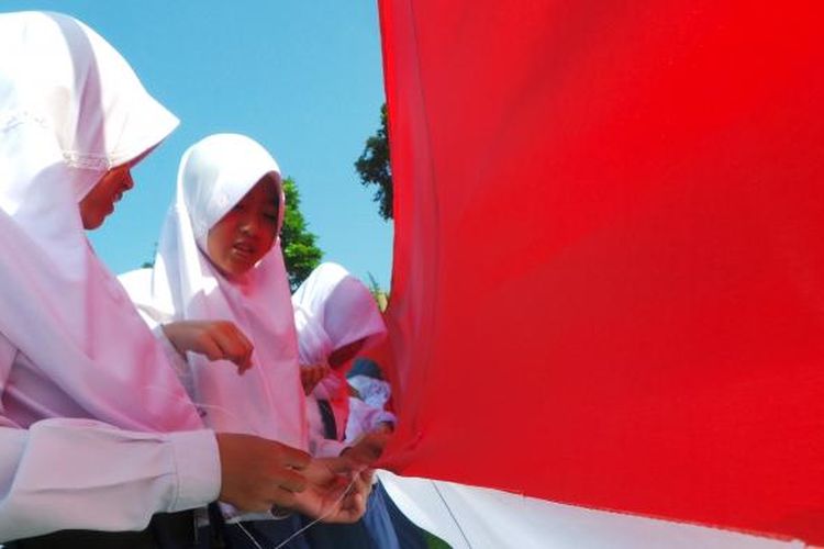 Ribuan pelajar di Bandungan, Kabupaten Semarang menjahit bendera merah putih sepanjang 71 meter di lapangan Jetis, Bandungan, Rabu (17/8/2016).