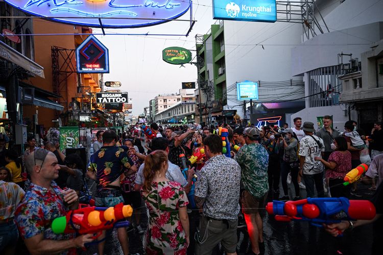 Foreign tourists and locals take part in water fights to celebrate Thai New Year, locally known as Songkran, at Khao San Road in Bangkok on April 13, 2022. (Photo by Lillian SUWANRUMPHA / AFP)