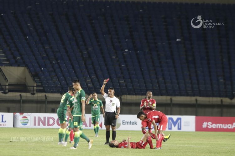 Wasit Agus Fauzan memberi kartu merah pemain muda Persebaya Surabaya Rizky Ridho seusai melanggar pemain Persik Kediri pada laga perdana babak penyisihan Grup C yang berakhir dengan skor 2-1 di Stadion Si Jalak Harupat Bandung, Selasa (23/03/2021) malam. 
