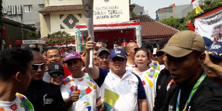 Menteri Perencanaan Pembangunan Nasional Indonesia Bambang Brojojonegoro menjadi salah satu pelari yang membawa obor dalam torch relay Asian Games 2018 di titik Kelurahan Tanah Sereal, Jakarta Barat pada Kamis (16/8/2018).