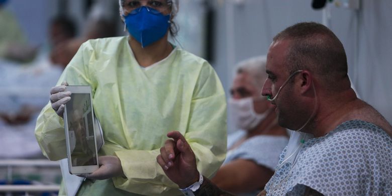 Seorang pasien yang terinfeksi virus corona berbicara dengan keluarganya melalui panggilan video di rumah sakit lapangan yang didirikan di gim Santo Andre, Sao Paulo, Brasil, pada 11 Mei 2020.