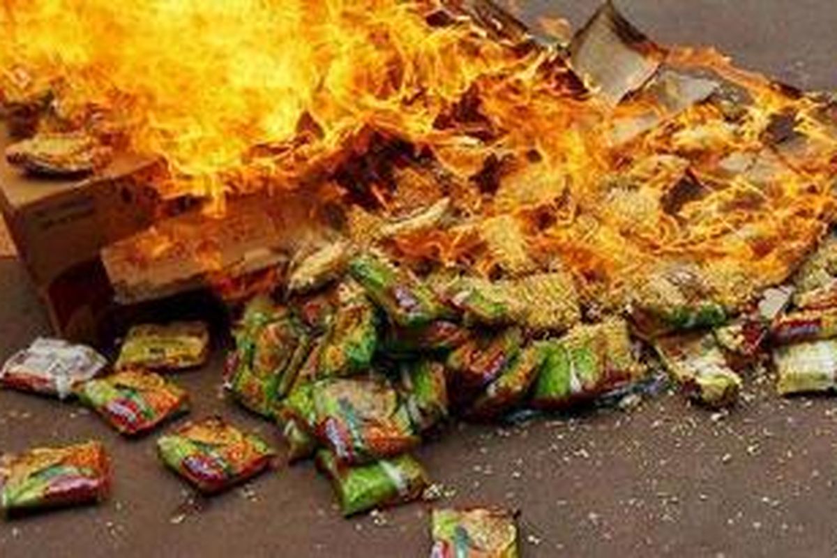 Aksi pembakaran mi instan merek Indomie oleh aktivis Visi Indonesia Sehat (VIS) di depan kantor pusat Indofood, Jalan Sudirman, Jakarta Selatan, Rabu (13/10/2010). Mereka mendesak Badan Pengawasan Obat dan Makanan (BPOM) menarik Indomie dari peredaran di pasar domestik. Aksi ini sempat berlangsung tegang karena para demonstran membakar mi instan tersebut.