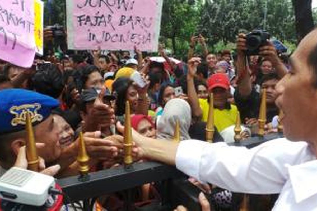 Gubernur DKI Jakarta Joko Widodo bersalaman dengan pendukung langkahnya menjadi capres di depan Balaikota, Selasa (1/4/2014).