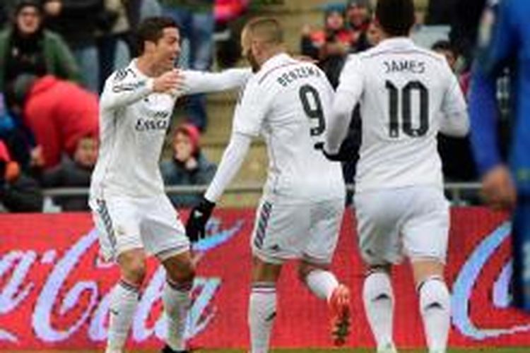 Bintang Real Madrid, Cristiano Ronaldo, bersukacita dengan rekannya, Karim Benzema, seusai mencetak gol ke gawang Getafe, Minggu (18/1/2015). 