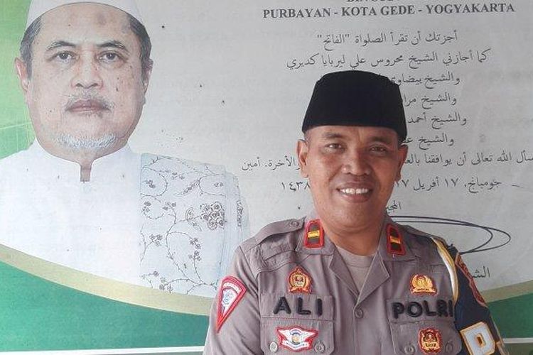 Ipda Ali Nur Suwandi berfoto bersama potret KH Djamaluddin Ahmad guru ngajinya di pesantren, Minggu (10/4/2023)   