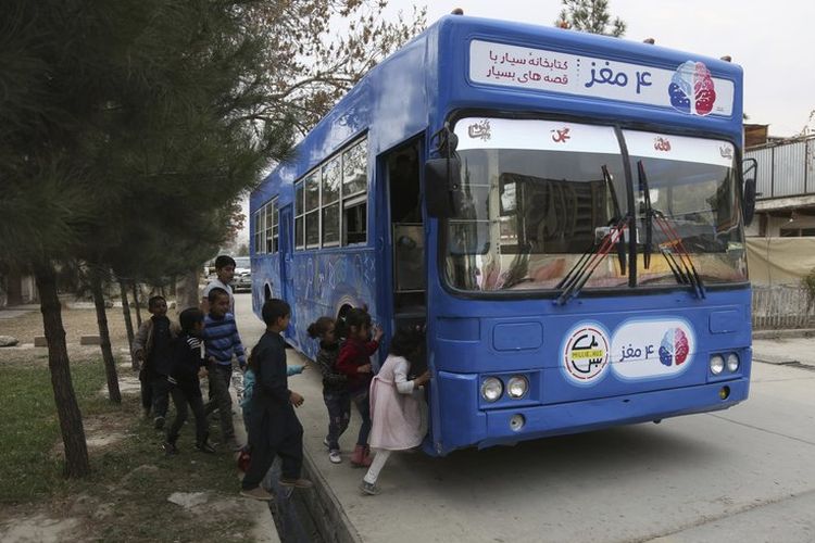 Anak-anak menaiki bus biru yang disulap menjadi sebuah perpustakaan di Kabul, Afghanistan. Bus yang dipenuhi buku bacaan untuk anak-anak itu menjadi hiburan baru bagi anak-anak di negara yang dilanda peperangan tersebut.