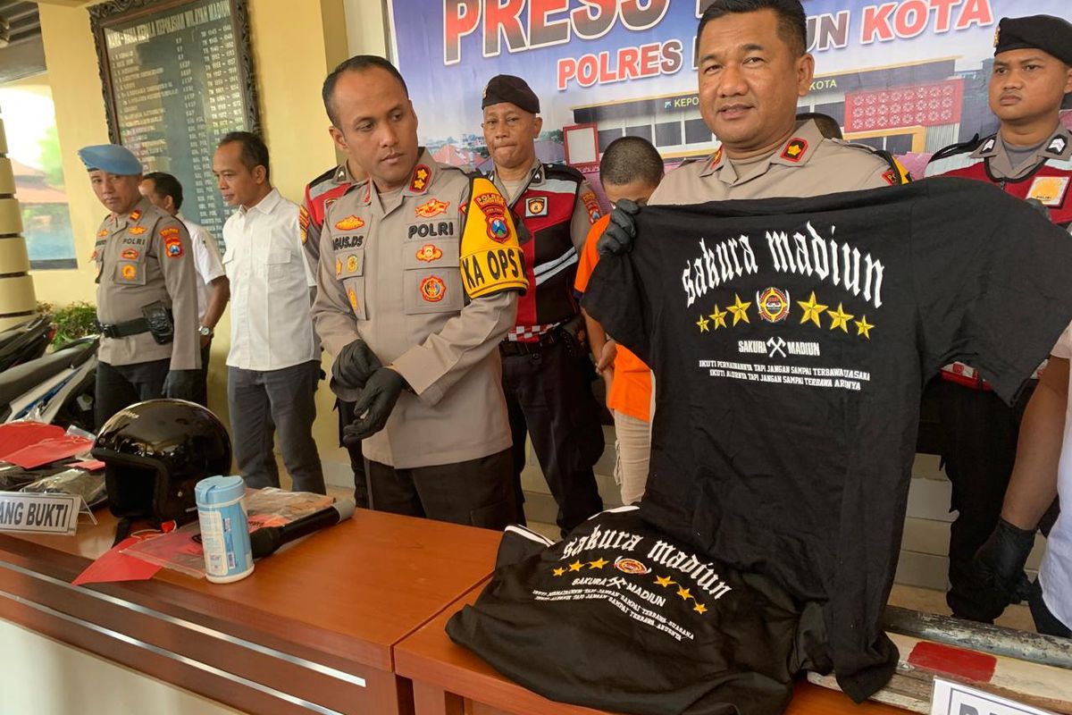 Kapolres Madiun Kota, AKBP Agus Dwi Suryanto menunjukkan kaos yang digunakan para tersangka dari Komunitas Sakura saat bentrok dengan pemuda lain di Kota Madiun, Rabu (5/6/2024).