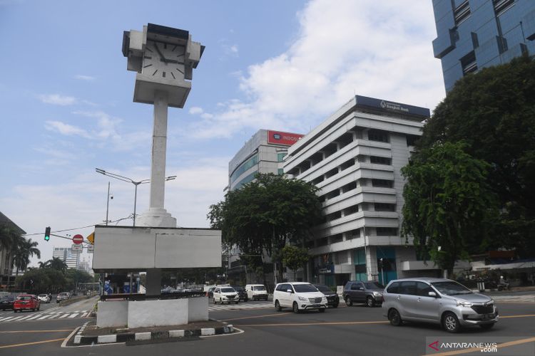 Sejumlah kendaraan melintasi Tugu Jam Thamrin di Jakarta, Minggu (8/11/2020). 