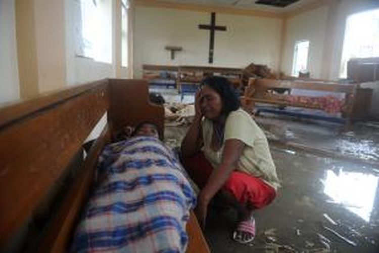 Seorang ibu menangisi jasad anaknya yang tewas akibat topan Haiyan yang menghantam kota Tacloban, Filipina, sejak Jumat (8/11/2013). Dikhawatirkan topan ini menewaskan sedikitnya 1.200 warga kota itu.