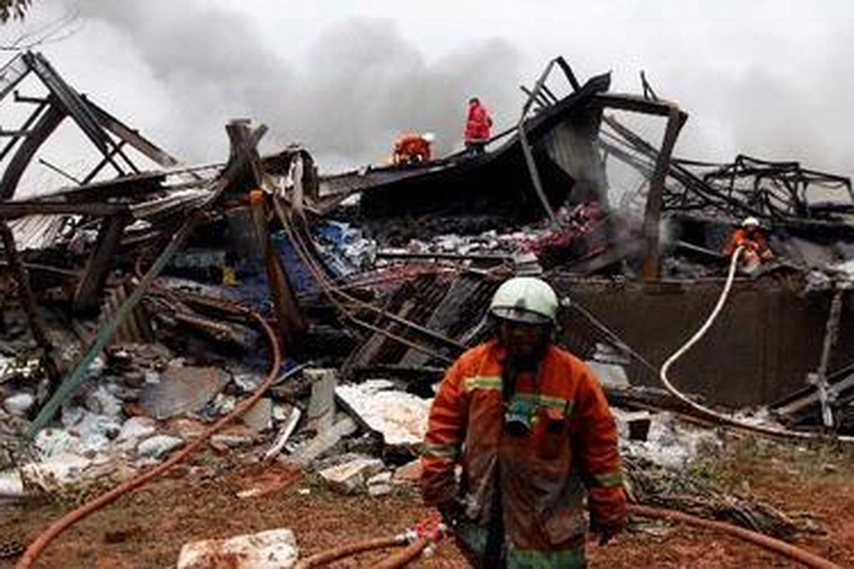 Petugas memadamkan sisa api dalam kebakaran di Pabrik Sandal Swallow, Kamal Raya, Jakarta Barat, Jumat (12/3/2010). Dari kebakaran yang terjadi sejak Kamis sore, dikabarkan sejumlah pekerja pabrik diduga terjebak dan belum diketahui nasibnya. 