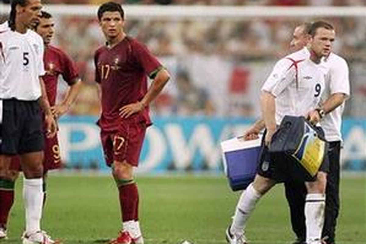 Striker Inggris, Wayne Rooney (kanan), meninggalkan lapangan pertandingan seraya disaksikan pemain Portugal, Cristiano Ronaldo (tengah), pada perempat final Piala Dunia 2006.