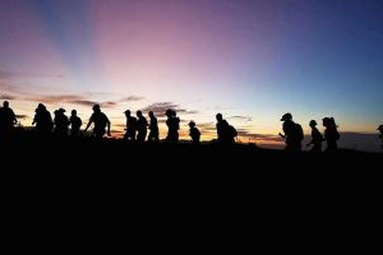 Pelari yang berpartisipasi dalam Tambora Trail Run melintasi padang sabana Doro Ncanga, Kabupaten Dompu, Provinsi Nusa Tenggara Barat, saat fajar menyingsing, Sabtu (11/4/2015). Lari lintas alam ini dibagi dalam dua kategori, yaitu lari 24 kilometer dan lari 42 kilometer melintasi hutan di kaki Gunung Tambora. 
