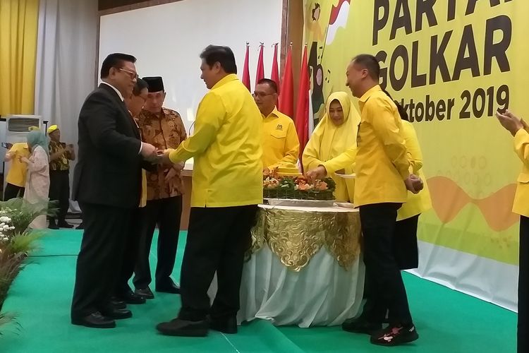 Ketua Umum Partai Golkar, Airlangga Hartarto, menyerahkan potongan tumpeng kepada Ketua Dewan Pakar Partai Golkar, Agung Laksono, saat syukuran ulang tahun ke-55 Partai Golkar di kantor DPP Partai Golkar, Minggu (20/10/2019)