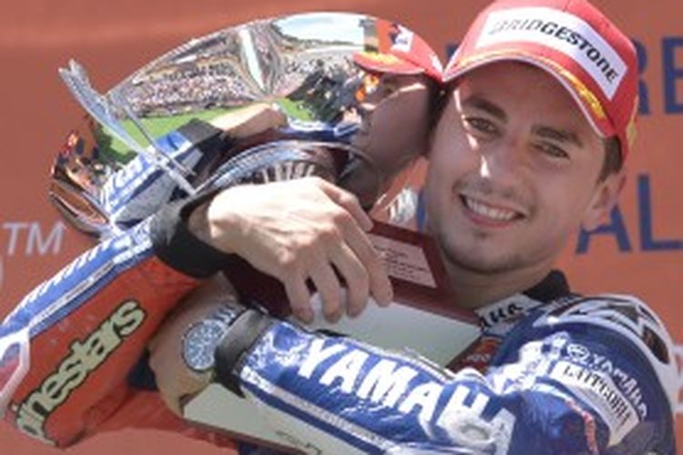 Pebalap MotoGP  asal Spanyol, Jorge Lorenzo, memeluk trofi setelah memenangi GP Catalunya, Minggu (16/6/2013).