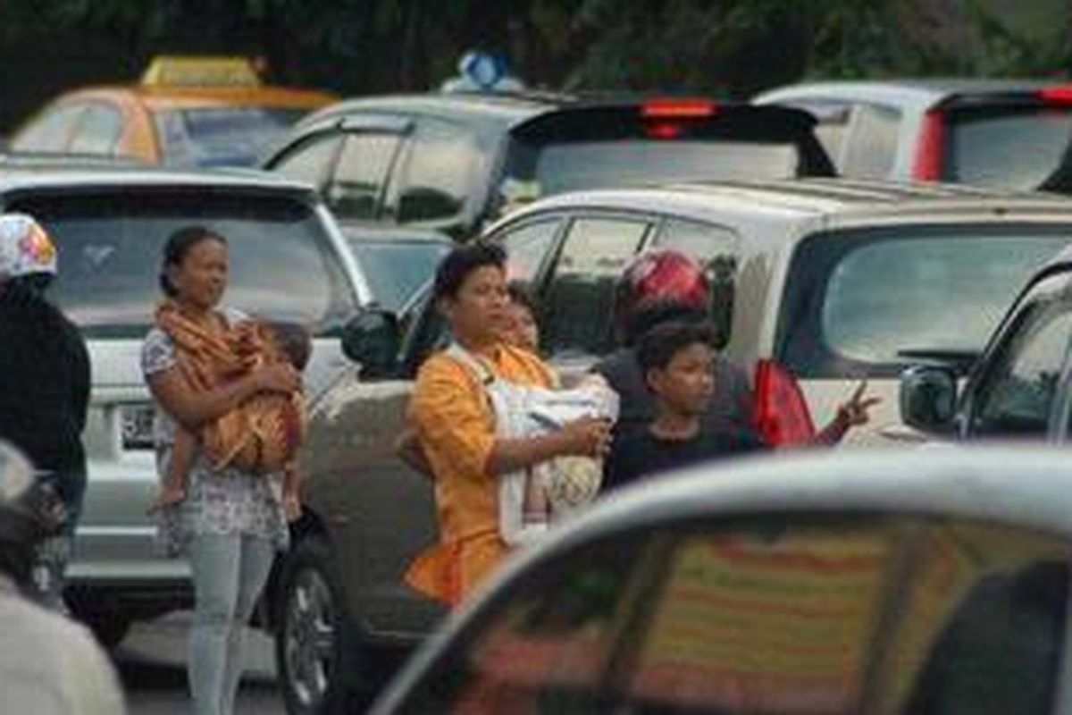 Seorang joki 3 in 1 menawarkan jasa kepada pengendara mobil yang lewat di ruas Jalan Gatot Subroto, Slipi, Jakarta, Selasa (28/9/2010). 