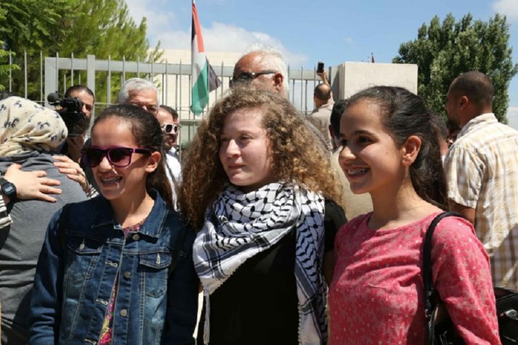 Ahed Tamimi (tengah) bersama pendukungnya setelah dibebaskan dari penjara Minggu (29/7/2018). Tamimi dipenjara delapan bulan setelah menampar seorang tentara Israel di Tepi Barat.