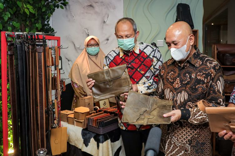 Minister of Cooperatives and Small and Medium Enterprises Teten Masduki (right) is holding a leather pouch produced by one of the Indonesian MSMEs. 