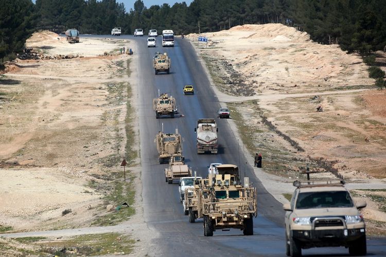 Kendaraan pasukan koalisi yang didukung AS melintas di jalanan di kota Manbij, selatan Suriah.