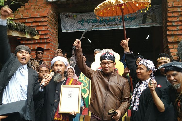 Gubernur Jawa Barat Ridwan Kamil (kanan tiga) memperlihatkan senjata kujang yang diterimanya di Pesantren Al Fath Sukabumi, Selasa (5/2/2019).