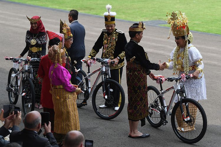 Presiden Joko Widodo (kedua kanan) memberi hadiah sepeda kepada tamu undangan yang mengenakan pakaian baju adat terbaik seusai memimpin Upacara Peringatan Detik-Detik Proklamasi Kemerdekaan Indonesia ke-74 Tahun 2019 di Istana Merdeka, Jakarta, Sabtu (17/8/2019). Tampak Sultan Gunung Tabur (ketiga dari kanan) ikut memenangkan kostum terbaik.